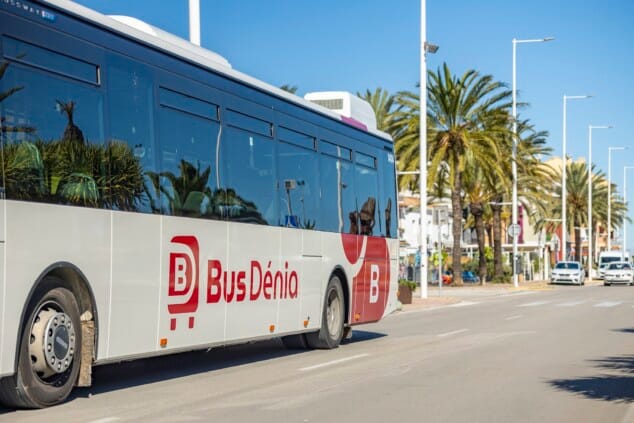 Imagen: Primer plano lateral de un autobús de la flota BusDénia circulando por el puerto