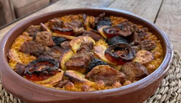 la presentacion final del arroz al horno en una cazuela de barro para compartir en familia