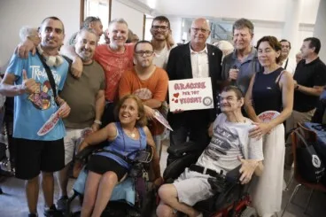 Miembros de la asociación Condenados al bordillo arropan a Vicent Grimalt y le entregan un cartel de agradecimiento