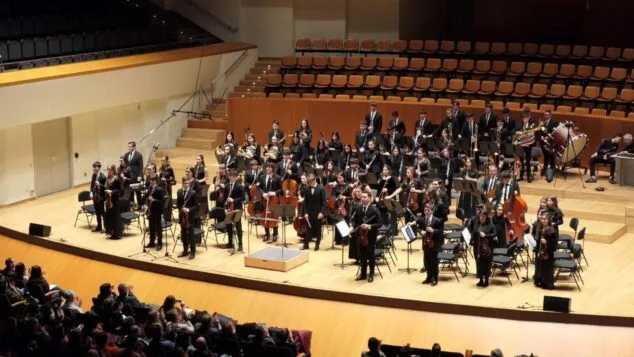 La Orquesta de Jóvenes de la Provincia de Alicante debuta en Dénia con un concierto previo a su gira por Viena 4 Imagen: Orquesta de Jóvenes de la Provincia de Alicante (OJPA) tocando en un auditorio con público aplaudiendo.