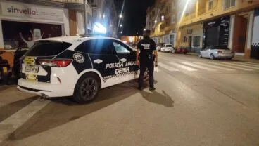 Coche patrulla y agente de la Policía Local de Dénia en un operativo nocturno.