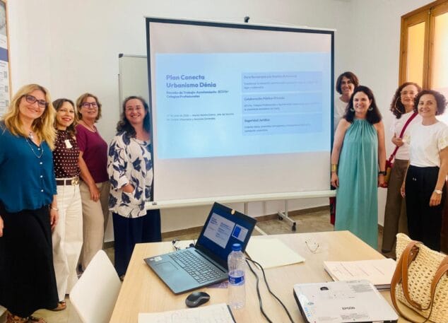 El Ayuntamiento de Dénia mueve ficha para desatascar las licencias urbanísticas 2 Imagen: Foto de grupo de participantes en una reunión de trabajo sobre urbanismo en Dénia frente a una pantalla de proyección.