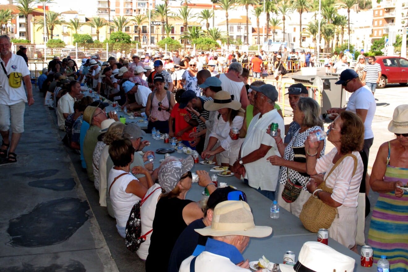 Vecinos y turistas comparten mesa en el multitudinario almuerzo popular organizado en el aparcamiento de la Llotja