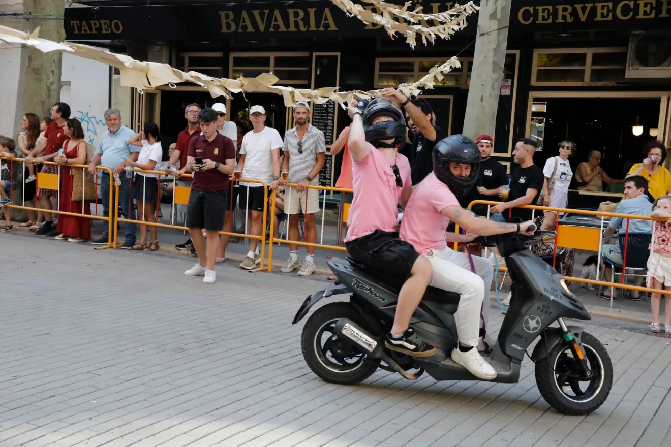 Piloto y pasajero de scooter pasando por debajo de las cintas en Marqués de Campo