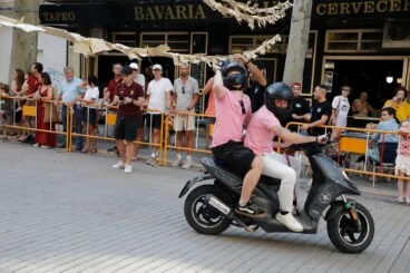 Piloto y pasajero de scooter pasando por debajo de las cintas en Marqués de Campo
