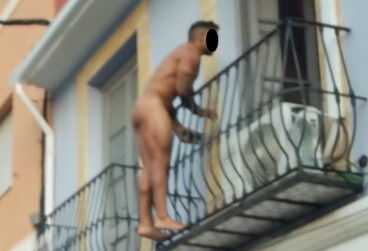 el individuo subido a la barandilla de la vivienda en los momentos previos a descolgarse hacia la via publica 1