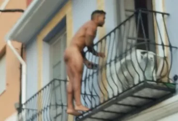 Escena surrealista en el centro de Dénia: la Policía intercepta a un hombre desnudo en plena vía pública 11 el individuo subido a la barandilla de la vivienda en los momentos previos a descolgarse hacia la via publica