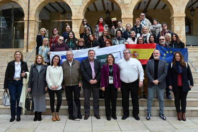 Foto de grupo de las delegaciones internacionales del proyecto Erasmus+ en las escaleras de UNED Dénia con banderas.