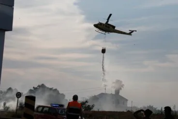 Helicóptero de bomberos realizando una descarga de agua sobre un incendio forestal en Dénia