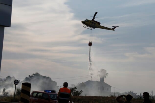 Imagen: Helicóptero de bomberos realizando una descarga de agua sobre un incendio forestal en Dénia