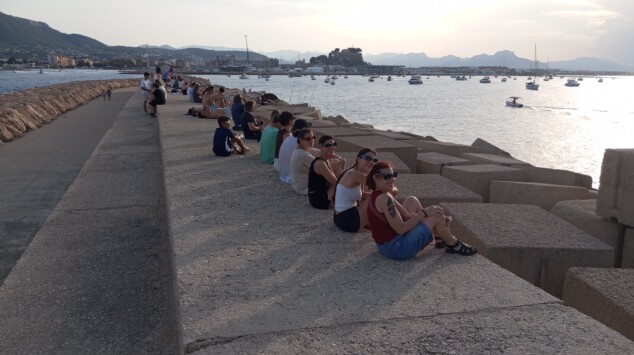 El eclipse solar en Dénia, entre la decepción por las nubes y un sobrecogedor apagón de última hora 1 Imagen: Personas esperando en las escolleras del puerto, con el Castell de Dénia al fondo y las gafas puestas