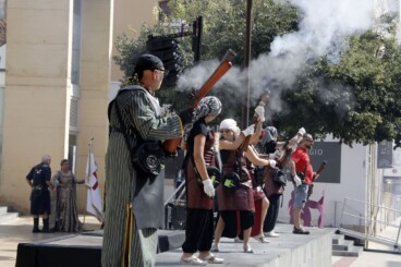 Representantes de las filaes moras y cristianas se alinean en la plaça del Consell de Dénia para la tradicional batalla de arcabucería