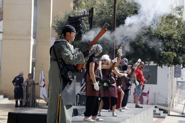 El atronador estallido de los arcabuces toma el centro de Dénia antes del esperado Milagro de la Niebla 2 Imagen: Representantes de las filaes moras y cristianas se alinean en la plaça del Consell de Dénia para la tradicional batalla de arcabucería