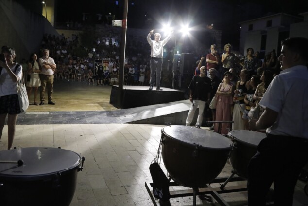 La cantera de los Moros y Cristianos toma Dénia: la espectacularidad del desfile infantil confirma el futuro de la fiesta 4 Imagen: Un director dirige a la formación musical desde un podio iluminado en la entrada de bandas