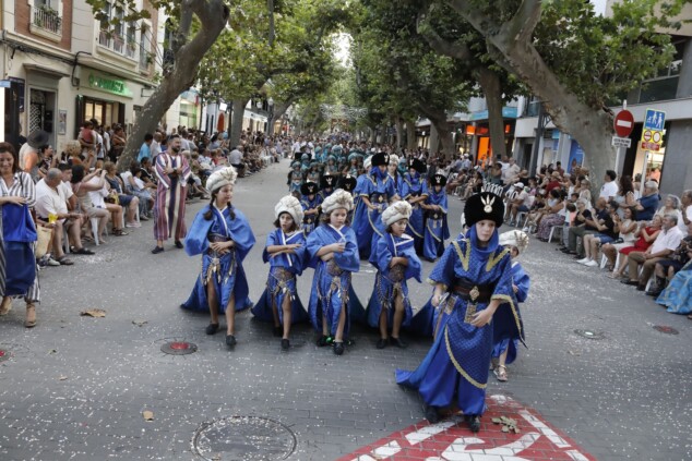 La cantera de los Moros y Cristianos toma Dénia: la espectacularidad del desfile infantil confirma el futuro de la fiesta 2 Imagen: Escuadra de niños vestidos con trajes moros de color azul recorre la calle Marqués de Campo bajo los plataneros