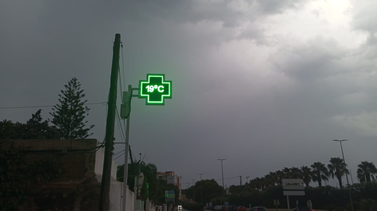 El termómetro de la farmacia marcando 19 °C bajo un cielo completamente plomizo antes de la tormenta