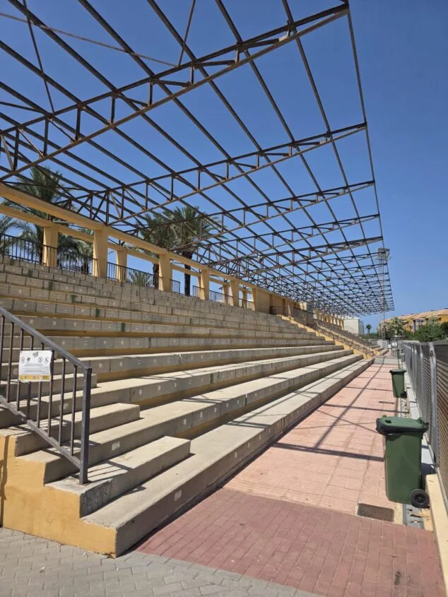 Las gradas de la pista de atletismo de Dénia reabren tras retirar la cubierta defectuosa 1 Imagen: Graderío de hormigón de la pista de atletismo de Dénia con la estructura metálica de la cubierta al descubierto tras su retirada.