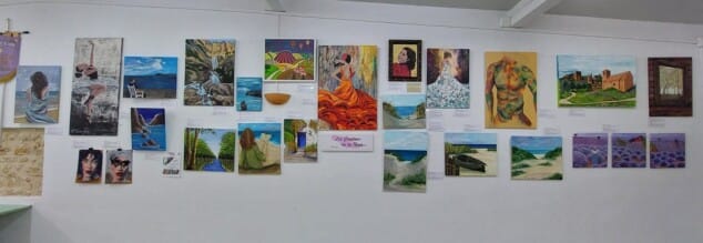 Imagen: Vista general de las pinturas de «Los cuadros de La Nena» expuestas sobre una pared blanca.