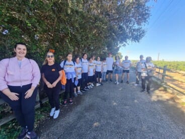 El grupo de ‘Dénia Camina’ posa junto a un campo antes de iniciar la marcha, algunos con camisetas oficiales