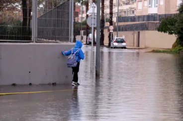 La vuelta al cole se complica en Dénia: la Aemet activa el aviso naranja por fuertes lluvias y granizo 4 estudiante intentando llegar al instituto con la calle anegada por la lluvia