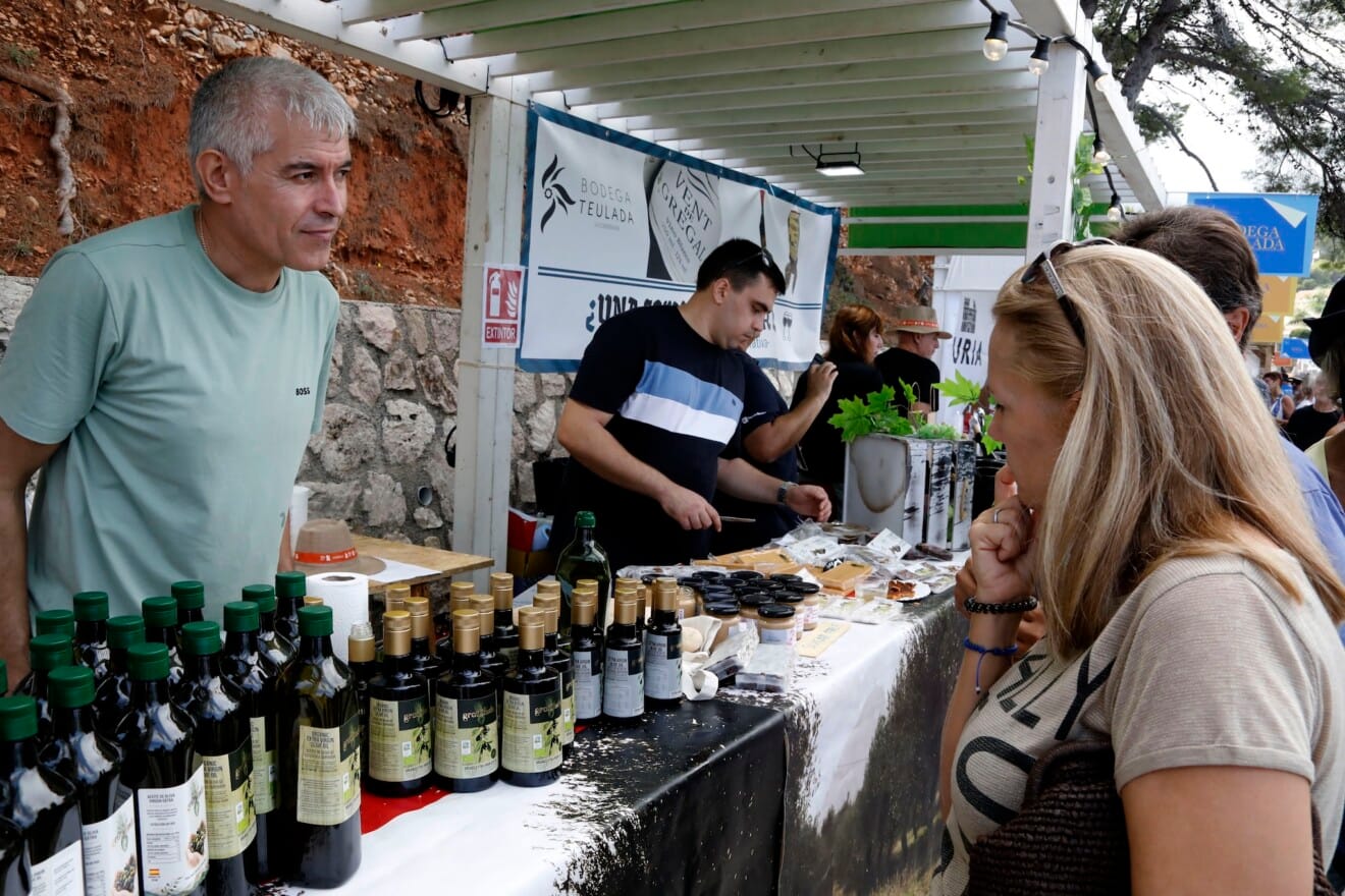 Un productor local atiende a una visitante en la parada de aceite de oliva artesanal