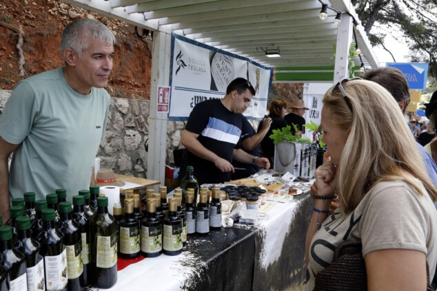 «Tenéis que estar orgullosos de vuestra cocina»: Ferran Adrià rinde homenaje al D*na Festival en Dénia 3 Imagen: Un productor local atiende a una visitante en la parada de aceite de oliva artesanal