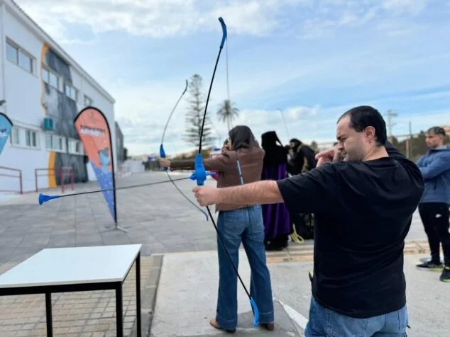 Un hombre apunta con un arco y flecha de ventosa durante una actividad del JOAFEST.