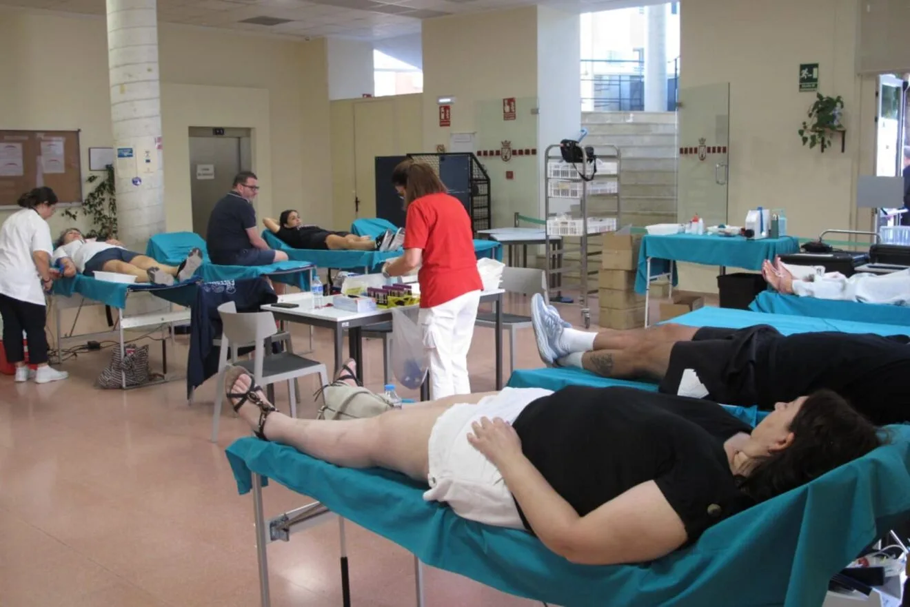 Interior del Centro Social de Dénia con varias personas en camillas donando sangre y personal sanitario atendiéndolas durante la maratón.