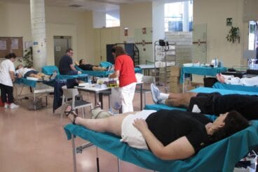 Interior del Centro Social de Dénia con varias personas en camillas donando sangre y personal sanitario atendiéndolas durante la maratón.