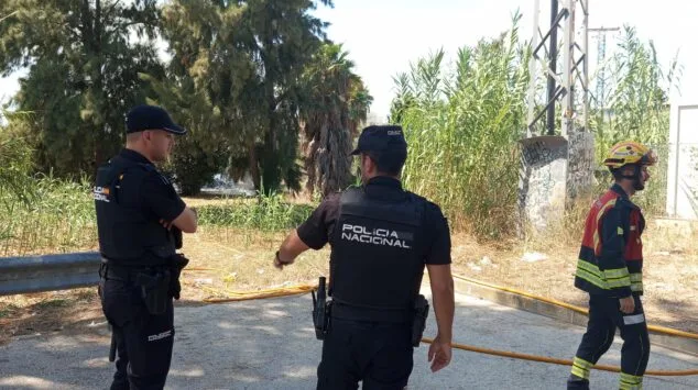 Dos agentes de la Policía Nacional y un bombero en el lugar del incendio en Dénia.