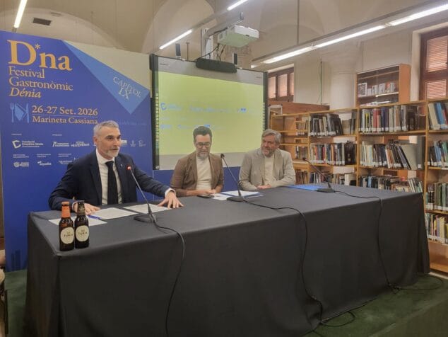 Imagen: José Manuel Camarero hablando en una mesa durante la presentación del D*na Festival 2026 en una biblioteca con carteles del evento.