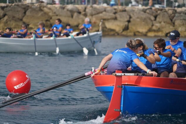 Más de un centenar de deportistas participaron en el III Desafío de 100 Paladas Solidarias en Dénia 3 Equipo de remeras compitiendo en una embarcación tradicional de remo durante la regata solidaria en Denia, con una boya roja de Liga Suma.