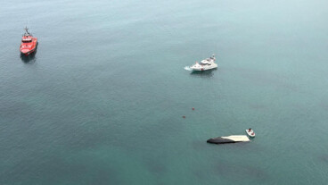 Velero eléctrico volcado y semihundido en el puerto de Dénia durante el operativo de emergencia