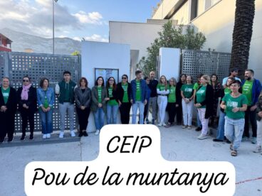 Grupo de docentes con camisetas verdes concentrados frente a la entrada del colegio CEIP Pou de la Muntanya en Dénia.