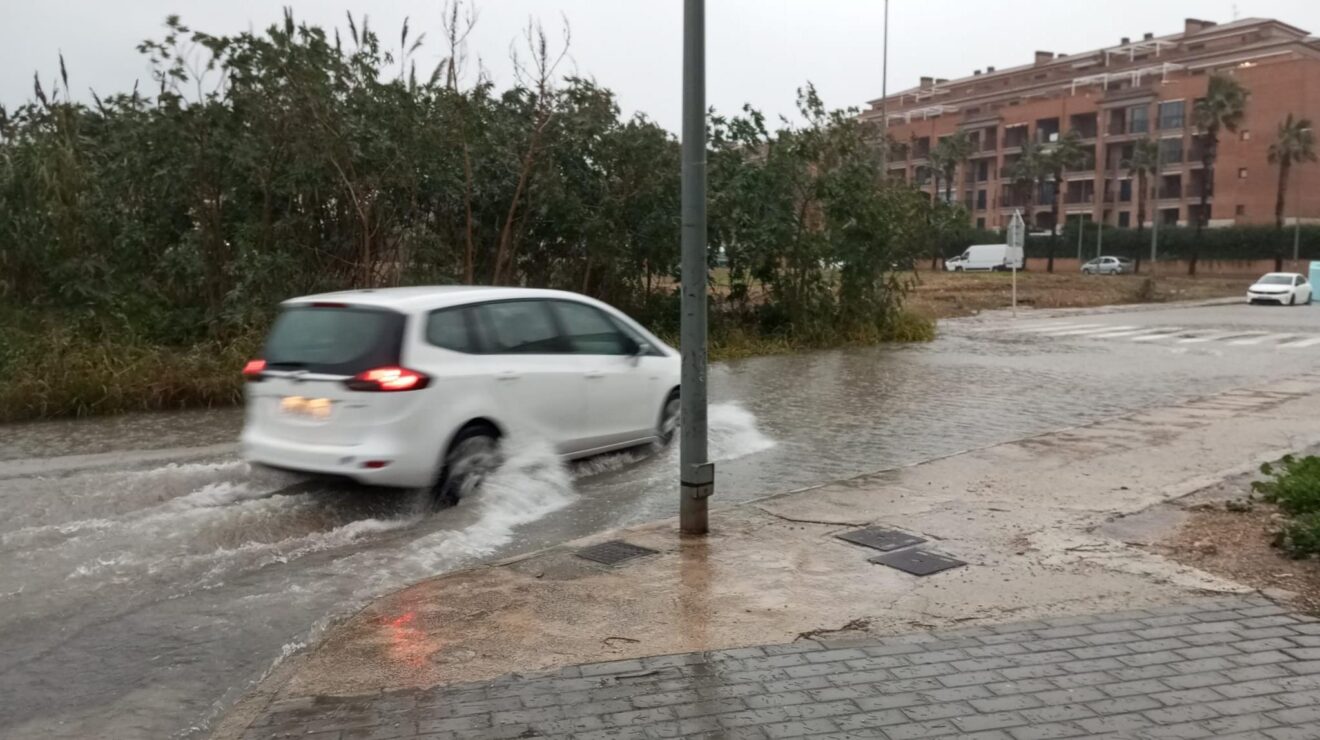 Vehículo circulando por una calle inundada durante un episodio de fuertes lluvias