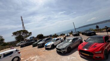 Dénia se prepara para un encuentro internacional de Mustang que rugirá por la investigación del cáncer infantil 4 Varios coches Ford Mustang aparcados en una concentración en un terreno de tierra cerca del mar