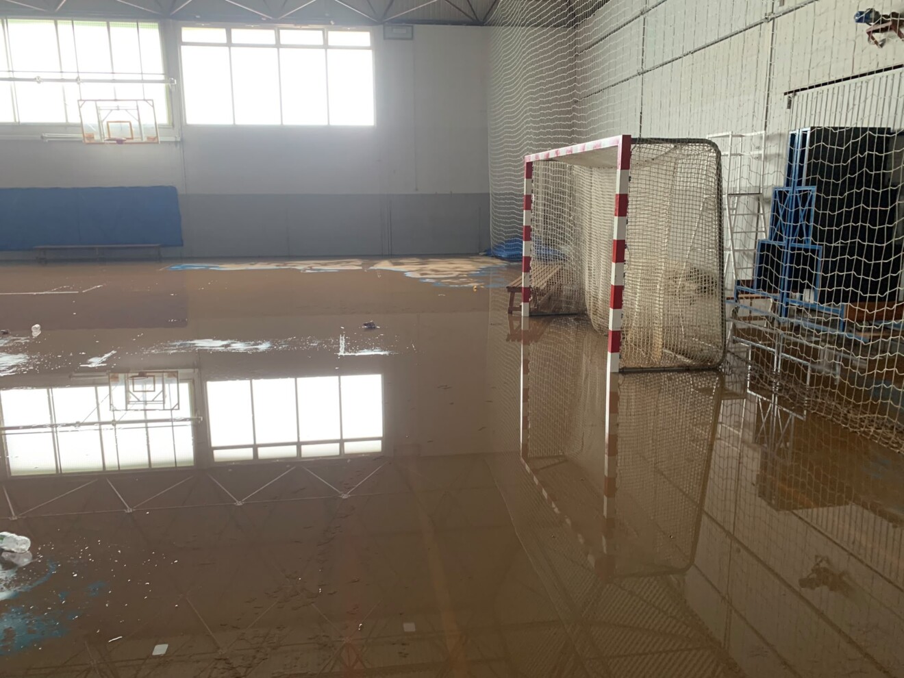 La pista del pabellón cubierto completamente anegada de agua tras el paso de la DANA