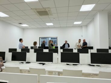La DGT prueba la nueva aula de exámenes teóricos informatizados en Dénia 5 Varios representantes de la DGT y el Ayuntamiento de Dénia inspeccionan una sala con filas de ordenadores para exámenes.